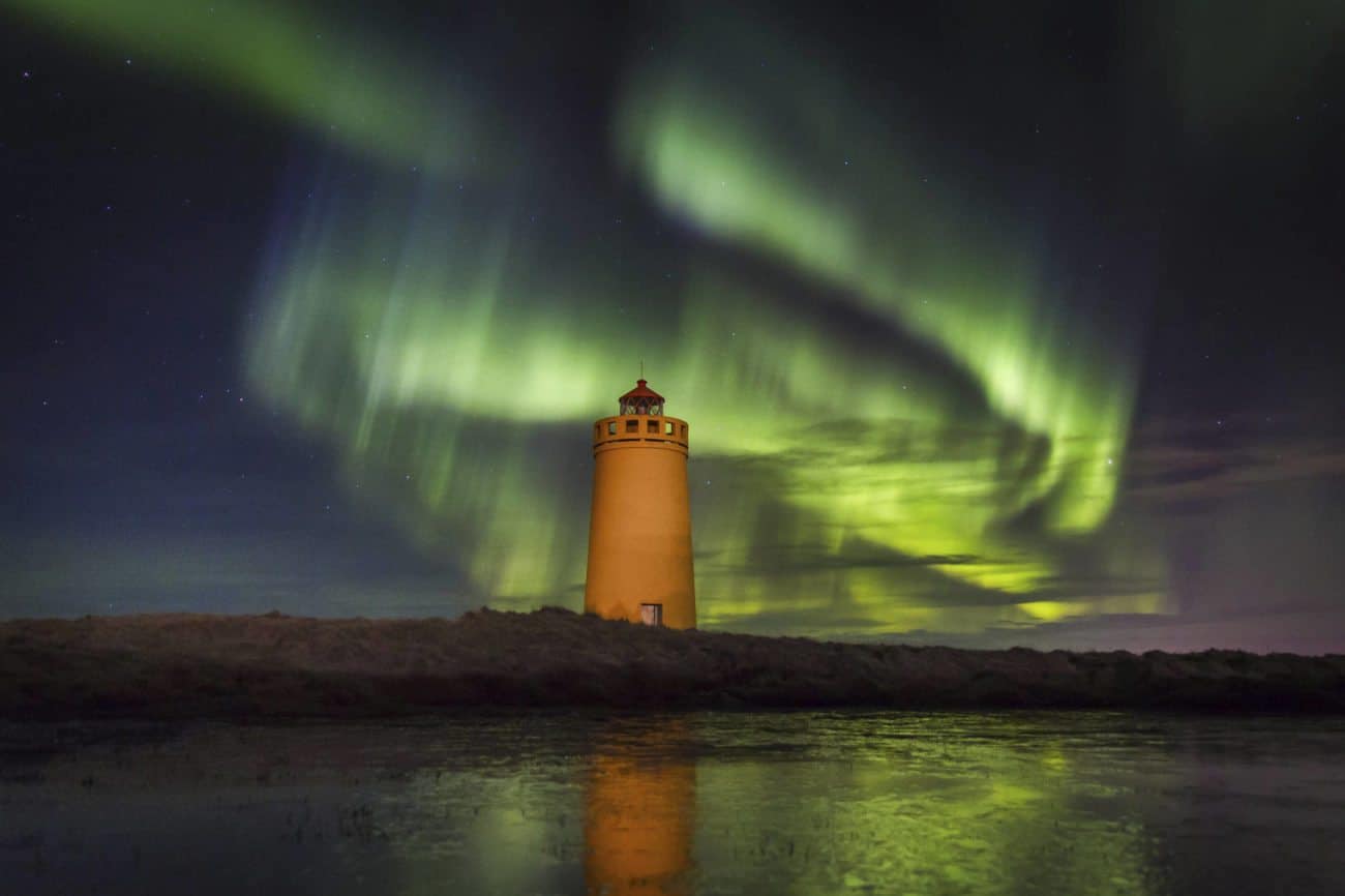 Northern lights dancing above a lighthouse 